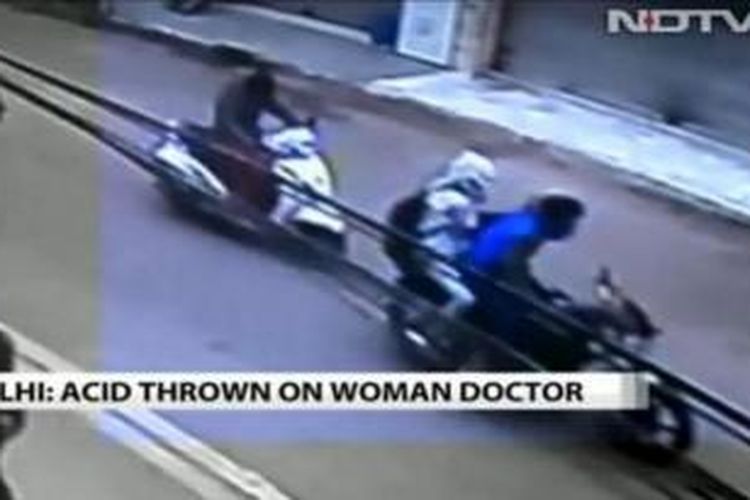 Foto ini diambil dari rekaman CCTV yang disiarkan stasiun televisi NDTV yang memperlihatkan dua pria yang mengendarai sepeda motor tengah melakukan serangan cairan asam terhadap seorang perempuan yang mengdarai sepeda motor di belakang mereka.