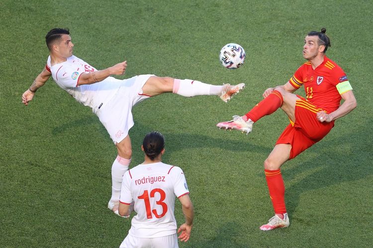 Gelandang Swiss Granit Xhaka (kiri) berduel dengan penyerang Wales Gareth Bale (kanan) pada laga atletico madrid fase grup Euro 2020 di Stadion Olimpiade Baku, Azerbaijan, Sabtu (12/6/2021) malam WIB.