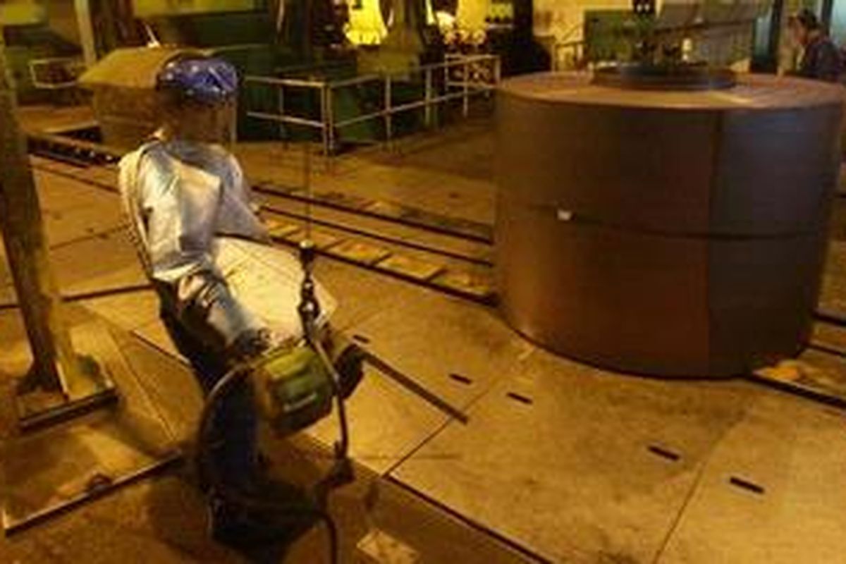 Pekerja mengikat gulungan baja lembaran panas (hot rolled coil) yang baru keluar dari mesin produksi PT Krakatau Steel, di Cilegon, Banten.