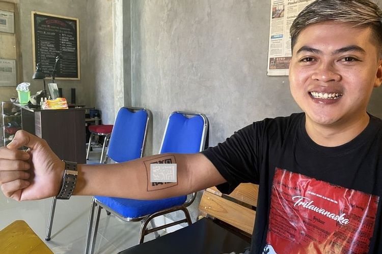 Yusuf Adhitya Putratama (30), warga Gunungkidul, DIY, menunjukkan tato QR code sertifikat vaksin Covid-19 miliknya.