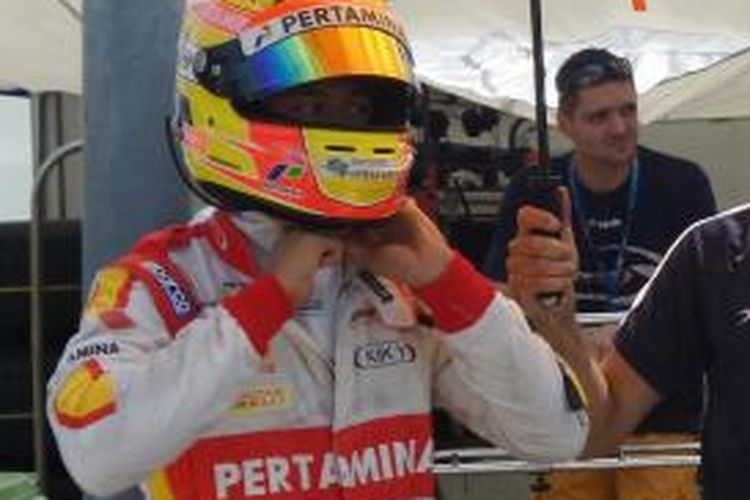 Pebalap Campos Racing asal Indonesia, Rio Haryanto, memasang helm sebelum turun pada sesi latihan GP2 Hongaria di Sirkuit Hungaroring, Jumat (24/7/2015).