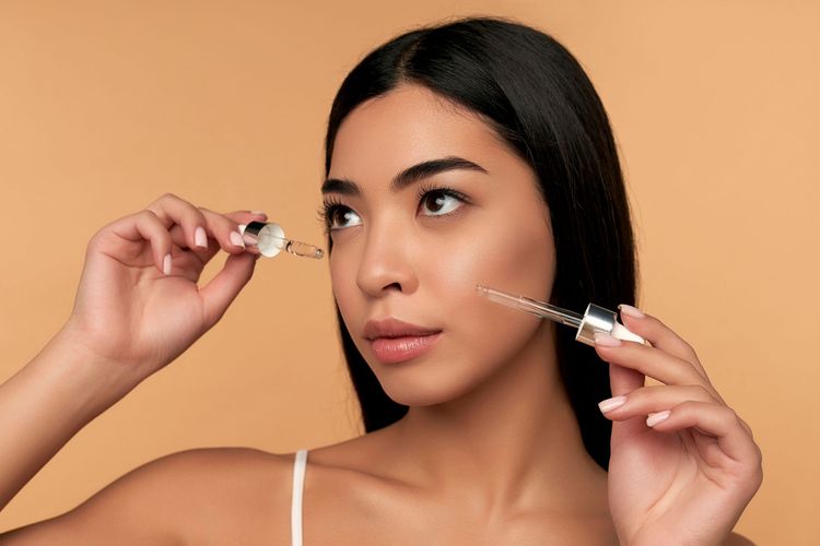 Ilustrasi seorang perempuan memakai retinol dengan bahan aktif lain secara bersamaan (layering).
