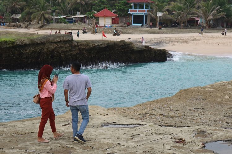 Wisatawan tampak berjalan di atas karang Pantai Klayar, Pacitan, Jawa Timur, Selasa (28/1/2020).