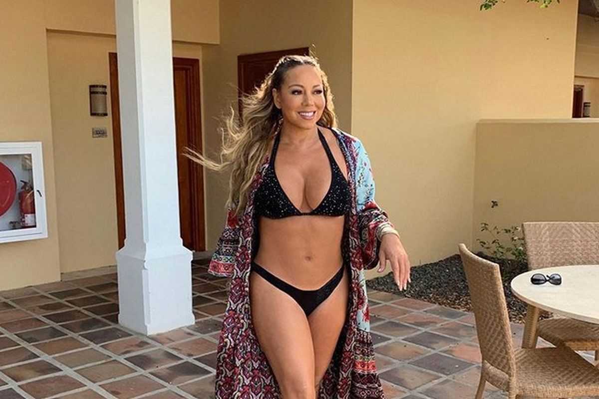 Mariah Carey dalam balutan bikini hitam yang menonjolkan otot di perutnya, sebuah capaian yang luar biasa bagi perempuan berusia 49 tahun.