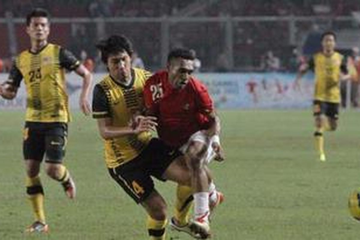 Pemain U23, Titus Bonas (kanan), ditabrak pemain belakang Malaysia pada pertandingan penyisihan grup A SEA Games XXVI di Stadion Gelora Bung Karno, Jakarta Pusat, Kamis (17/11/2011). Malaysia memenangkan pertandingan dengan skor 1-0.