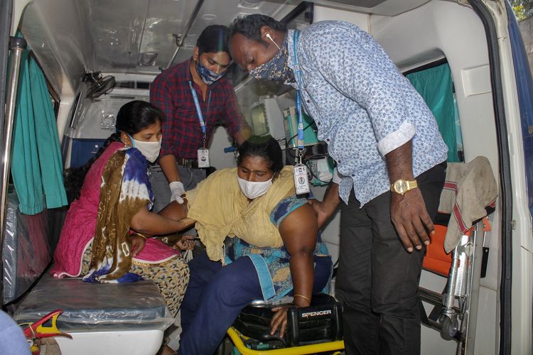 Seorang pasien dibantu lainnya turun dari ambulans ke rumah sakit pemerintah Eluru, Andhra Pradesh, India, pada 8 Desember 2020. Pejabat dan pakar kesehatan masih berjuang mengungkap penyakit misterius yang membuat lebih dari 500 orang dirawat, dan satu orang meninggal.