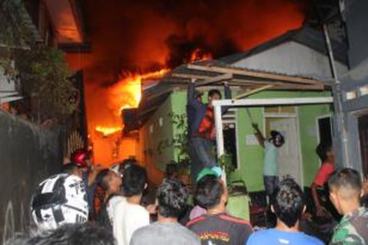 Warga di Jalan Baru, Kecamatan Sirimau, Ambon mengungsikan barang-barangnya setelah kebakaran terjadi di kawasan itu, Sabtu (31/10/2014) malam.