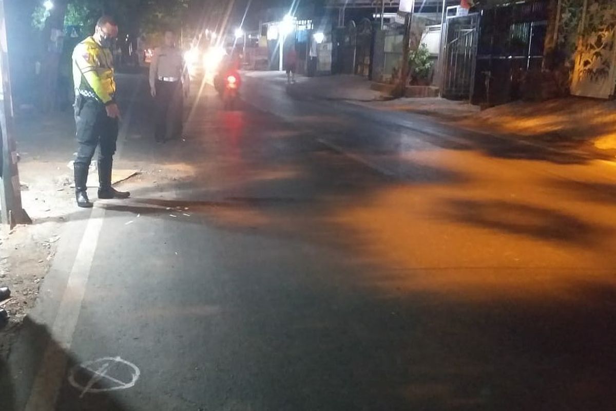 Petugas menunjukkan lokasi korban terlibat kecelakaan lalu lintas hingga tewas di Jalan Raya Desa Laban, Kecamatan Menganti, Gresik, Jawa Timur, Kamis (12/10/2023).