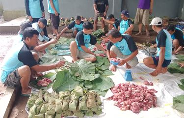 Panitia membungkus daging kurban menggunakan daun jati di Mushala Mutmainah, Desa Kracak, Kecamatan Ajibarang, Kabupaten Banyumas, Jawa Tengah, Kamis (29/6/2023).