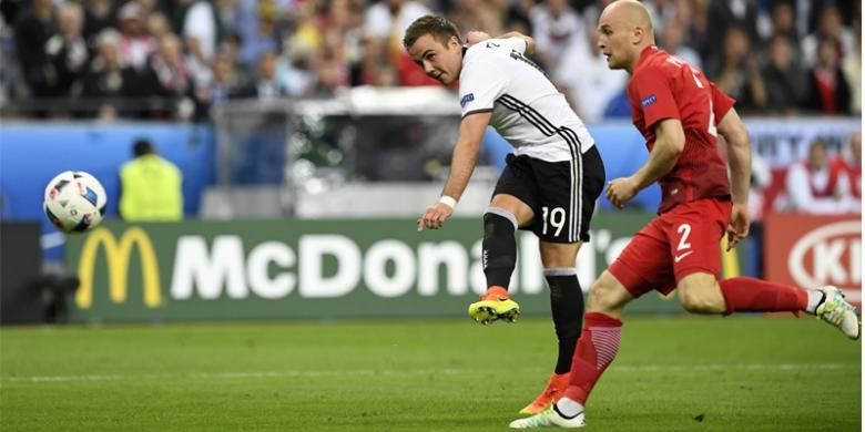 Penyerang Jerman Mario Goetze (kiri) melepaskan tembakan dan bek Polandia, Michal Pazdan, berusaha menghalau ketika kedua tim bertemu dalam laga penyisihan Grup C Piala Eropa 2016 di Stadion Stade de France, Saint-Denis, Kamis (16/6/2016).