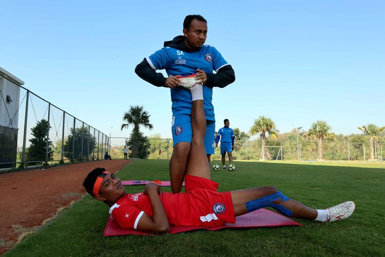 Pemain Arema FC Dedik Setiawan melakukan terapi bersama dokter tim. 