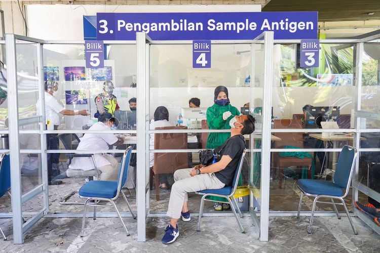 Calon penumpang kereta api jarak jauh sedang melakukan tes rapid antigen di stasiun.