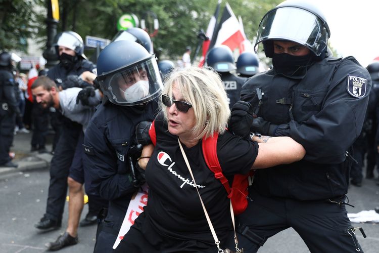Polisi menahan seorang demonstran dalam aksi unjuk rasa menentang peraturan pemerintah melawan virus corona di Berlin, Jerman, pada 29 Agustus 2020.