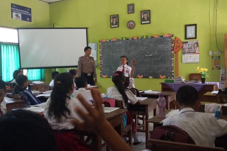 Suasana saat anggota Polres Blitar saat mengajar di sekolah dasar karena ditinggal gurunya ikut aksi mogok massal dan demonstrasi, Rabu (26/9/2018) 