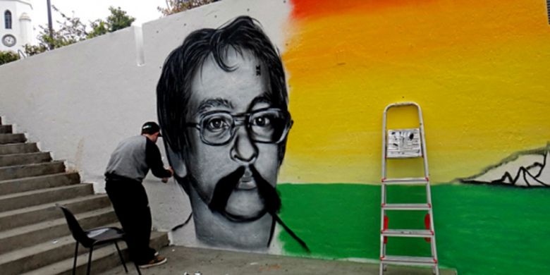 Seniman grafiti tengah melukis wajah penyair Paulo Leminski di Galeri Julio Moreira, Largo da Ordem, Curitiba, Brazil.