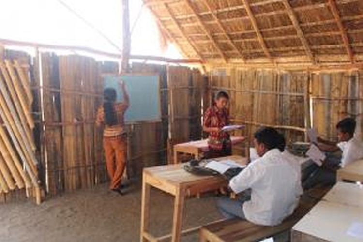 Petronela Kenjam (kiri) dan Meliana Eba (kanan) dua orang guru SMK Kristen Huetalan, Kabupaten Timor Tengah Selatan (TTS), NTT, sedang mengajar di ruang kelas yang darurat