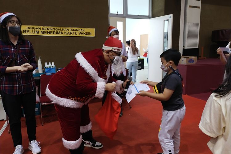 Santa Claus Yang Bertugas Menghilangkan Rasa Tegang Anak Saat Vaksin, Sabtu (18/12/2021).