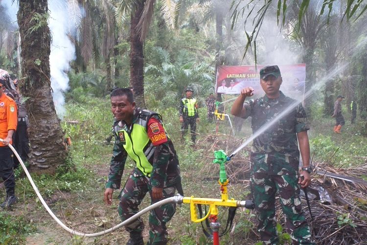 Dandim 0321/Rohil Letkol Arh Agung Rakhman Wahyudi saat melakukan simulasi alat Sambunesia Nozzle untuk memadamkan titik api karhutla di Kecamatan Bagan Sinembah Raya, Kabupaten Rohil, Riau, Sabtu (15/2/2020).