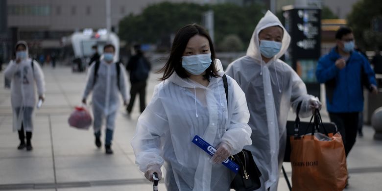Orang-orang mengenakan masker sampai di Stasiun Kereta Hankou, Wuhan, untuk menumpang kereta pertama setelah pemerintah mencabut lockdown guna menangkal virus corona pada 8 April 2020. Sudah 76 hari warga ibu kota Hubei tersebut dikarantina demi mencegah penyebaran wabah.
