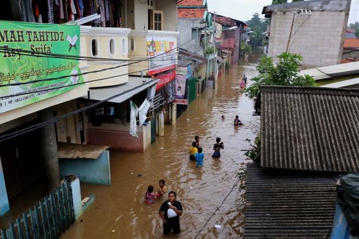 Warga berjalan menembus banjir di Kelurahan Cipinang Melayu, Kecamatan Makasar, Jakarta Timur, Senin (20/2/2017). Banjir kerap terjadi menyusul meluapnya Kali Sunter yang melintasi Cipinang Melayu, ditambah, curah hujan yang tinggi sepanjang hari kemarin.