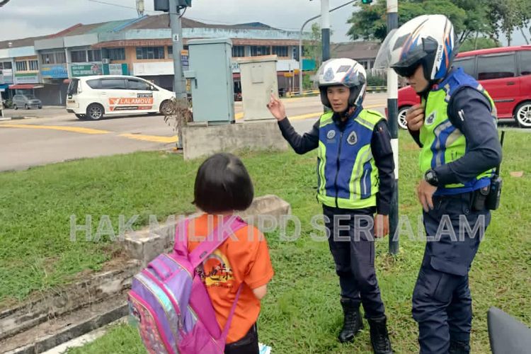 Dua polisi di Taman Johor Jaya, Malaysia, mengantar anak sekolah yang ketinggalan bus pada Senin (3/7/2023).