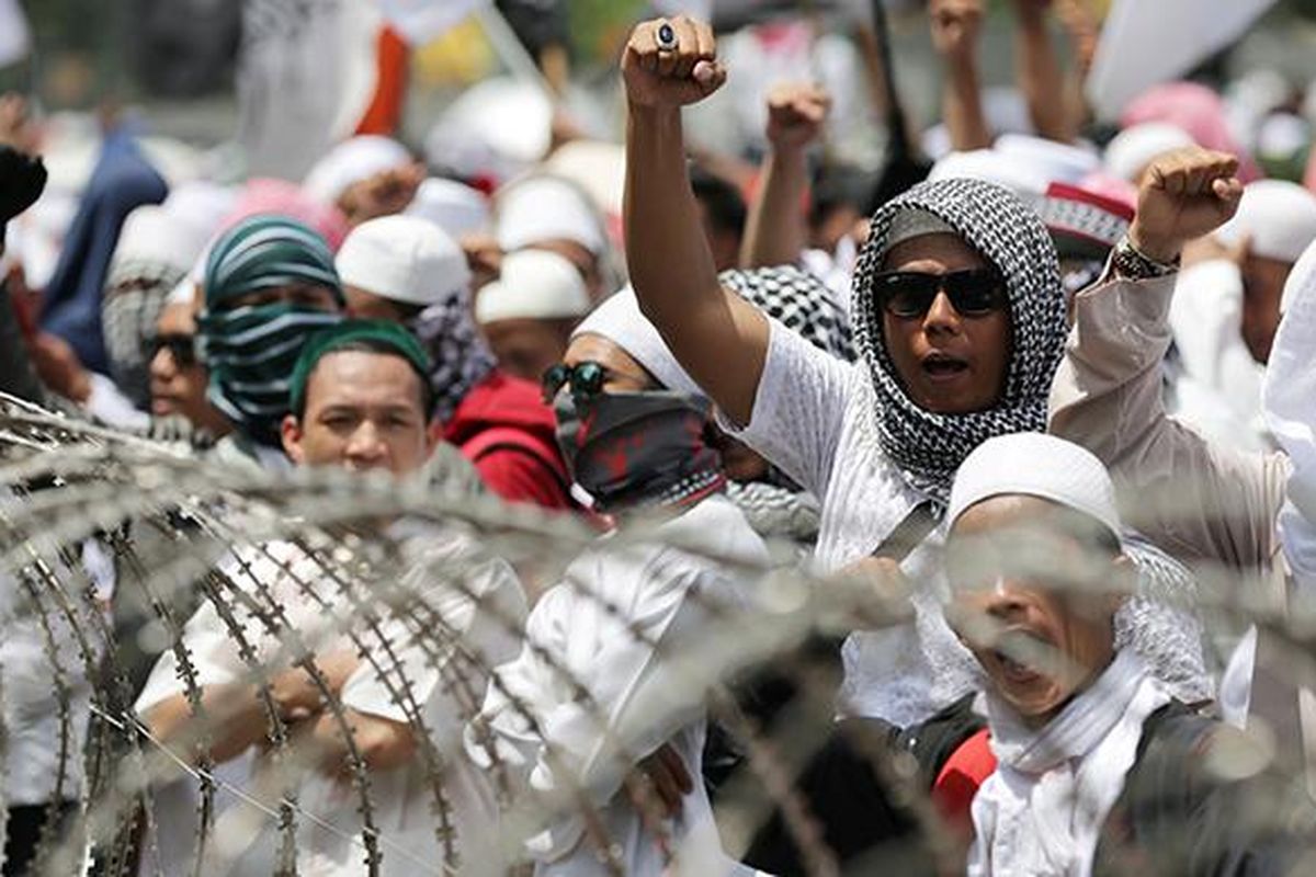 Massa Front Pembela Islam berunjuk rasa di depan Polda Metro Jaya, Jakarta, Senin (23/1/2017). Pimpinan FPI Rizieq Shihab diperiksa oleh Subdirekorat Fiskal, Moneter, dan Devisa Direktorat Reserse Kriminal Khusus Polda Metro Jaya, terkait ucapannya soal gambar palu arit di logo Bank Indonesia dalam lembaran uang rupiah.