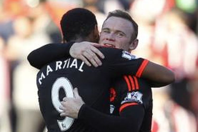 Penyerang Manchester United, Wayne Rooney, memeluk rekan setimnya, Anthony Martial, pada laga Premier League melawan Southampton di Stadion St Mary, 20 September 2015.