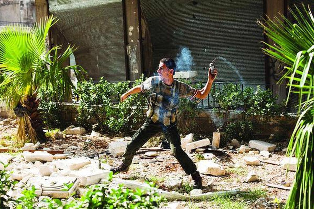 Anggota oposisi melemparkan granat buatan ke arah pasukan Suriah di Bustan al-Basha, Aleppo, Minggu (21/10). Utusan Khusus PBB Lakhdar Brahimi meminta kedua pihak yang terlibat konflik di Suriah melakukan gencatan senjata menjelang hari raya Idul Adha saat bertemu Presiden Suriah Bashar al-Assad.