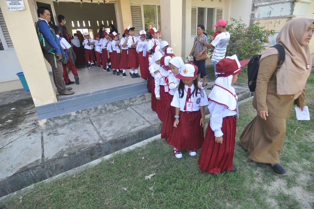 Sejumlah siswa dan siswi peserta didik baru diajak berkeliling untuk mengenal lingkungan pada hari pertama masuk sekolah di SDN Madani, Palu, Sulawesi Tengah, Senin (9/7). Seluruh siswa SD, SMP, SMA/SMK dan sederajatnya setempat mulai masuk kembali bersekolah pada tahun ajaran baru 2018/2019. 