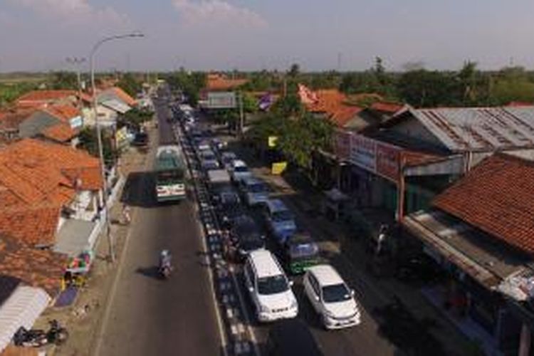 Kendaraan dari arah Jakarta yang menuju Jawa Tengah, Senin (13/7/2015) tersendat sekitar tiga kilometer di jalur pantura di Brebes, Jawa Tengah. Kendaraan dari Tol Kanci-Pejagan diarahkan keluar menuju jalur pantura. Kendaraan tersendat karena aktivitas warga dan pelintasan kereta.
