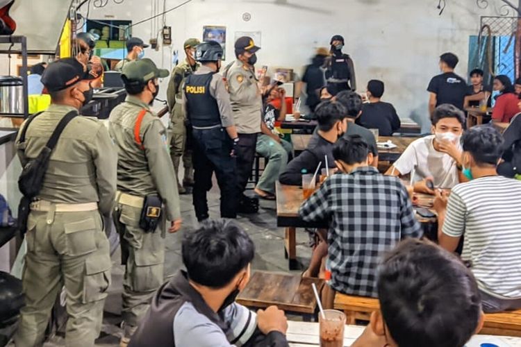 Petugas Satpol PP dan kepolisian membubarkan kegiatan nonbar pertandingan liga 2 antara Persis Solo vs Persijap Jepara di salah satu warung makan di kawasan Mangkubumen, Solo, Jawa Tengah, Selasa (5/10/2021) malam.