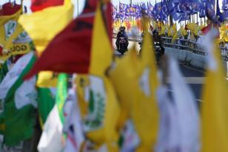 Meski telah memasuki masa tenang, bendera partai politik dan atribut calon legislatif masih bertebaran, seperti di Kawasan Matraman, Jakarta, Minggu (6/4/2014). Aparat penegak hukum harusnya bertindak tegas terhadap pelanggaran seperti ini.