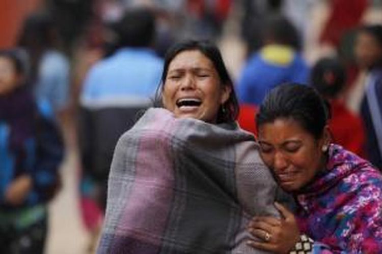Warga menangis saat kremasi massal korban gempa di Bhaktapur, dekat Kathmandu, Nepal, 26 April 2015. Gempa tektonik berkekuatan 7.9 SR mengguncang Nepal pada 25 April, mengakibatkan ribuan orang meninggal.