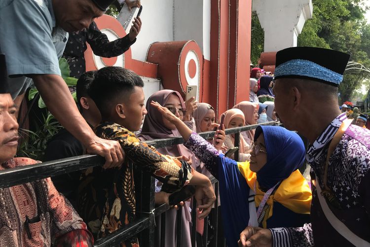 Salah satu calon jemaah haji asal Kabupaten Nganjuk saat berpamitan dengan keluarga saat proses pemberangkatkan haji di Pendopo KRT Sosrokoesoemo Pemkab Nganjuk, Selasa (4/6/2024)