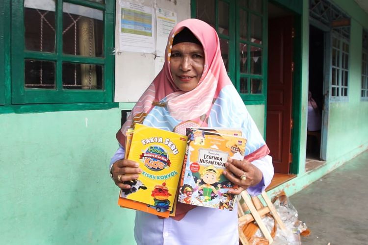 Kepala SD Alkhairaat Tobelo, Nursia Larahu memperlihatkan buku donasi dari tim Kata Ke Nyata, Jagat Literasi Kompas.com pada Rabu (29/10/2025)