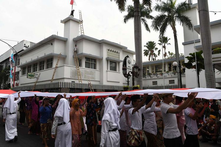 Peserta teatrikal membentangkan bendera Merah Putih saat memperingati peristiwa perobekan bendera di Hotel Yamato (kini Hotel Majapahit) di Jalan Tunjungan, Surabaya, Jawa Timur, Rabu (19/9/2018). Kegiatan tersebut dalam rangka memperingati peristiwa perobekan bendera Belanda menjadi bendera Indonesia pada 19 September 1945.