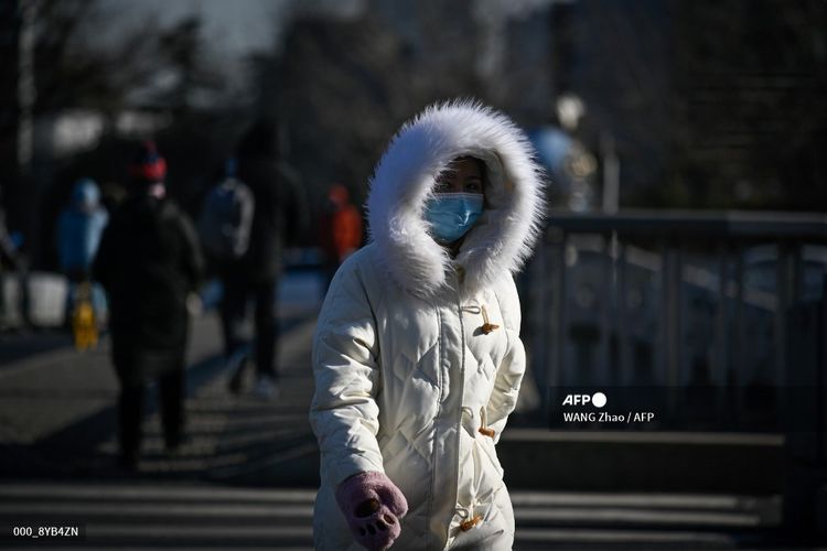 Seorang wanita memakai pakaian tebal untuk menghangatkan badan, saat berjalan dalam musim dingin yang menerpa Beijing, ibu kota China, pada Kamis (7/1/2021). Suhu Beijing saat itu mencapai -19,6 derajat Celsius, terendah dalam 50 tahun terakhir.