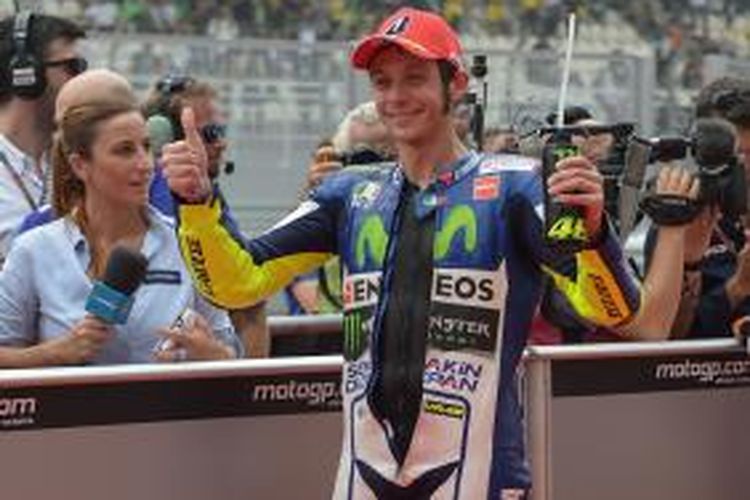 Pebalap Movistar Yamaha asal Italia, Valentino Rossi, merayakan setelah berhasil mengunci tempat start ketiga pada seri kualifikas GP Malaysia, di Sirkuit Sepang, Sabtu (24/10/2015).