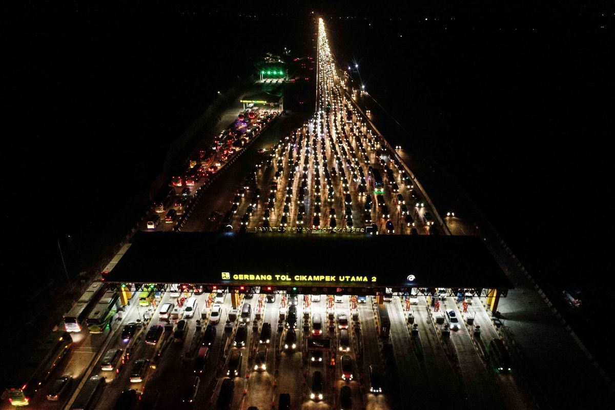 Foto udara kendaraan pemudik dari arah Jakarta melewati Gerbang Tol Cikampek Utama di malam hari di Cikampek, Jawa Barat, Sabtu (1/6/2019). Volume arus mudik dari arah Jakarta yang memasuki Gerbang Tol Cikampek Utama menuju ke sejumlah wilayah di Jateng dan Jatim pada H-4 siang hari terpantau padat merayap.