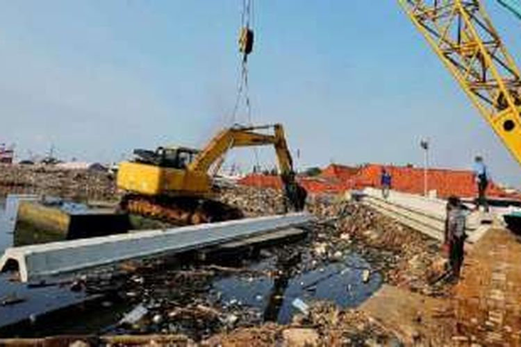 Ekskavator memindahkan sheet pile untuk pembangunan tanggul di Pasar Ikan, Penjaringan, Jakarta Utara, Jumat (16/9). Proyek pembangunan tanggul untuk mengatasi banjir rob di Pantai Utara Jakarta tersebut dijadwalkan selesai pada Desember 2016. 