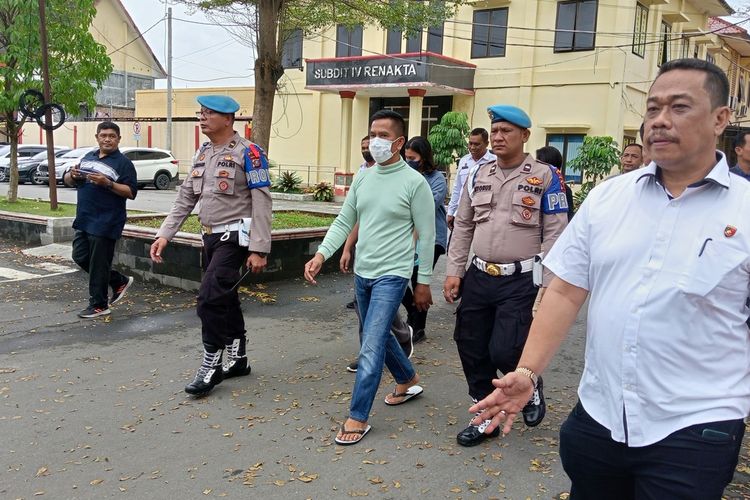 AKBP Achiruddin Hasibuan (kaus hijau) dikawal sejumlah personel polisi saat berjalan menuju gedung Direktorat Reskrimum Polda Sumut untuk diperiksa pada Kamis (27/4/2023) siang.