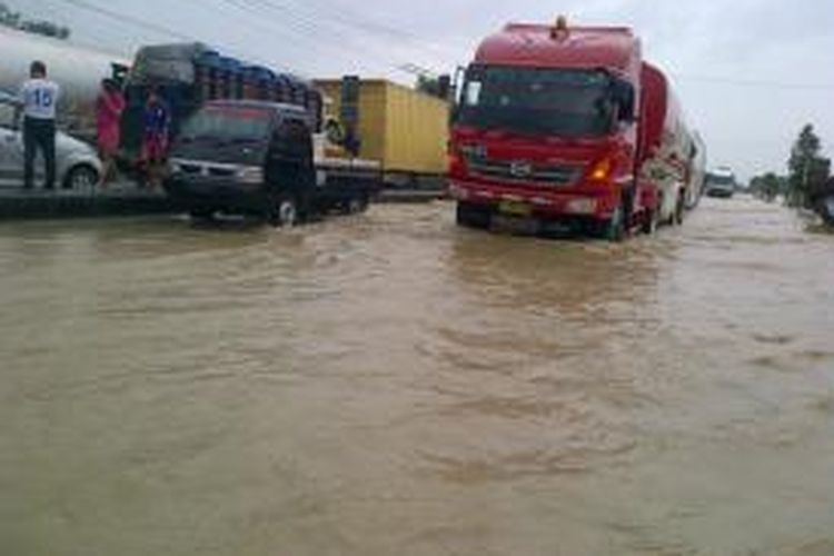 Kendaraan nekad melintas di jalur pantura Ulujami, Pemalang, Jawa Tengah, yang terendam banjir, Minggu (2/2/2014) 