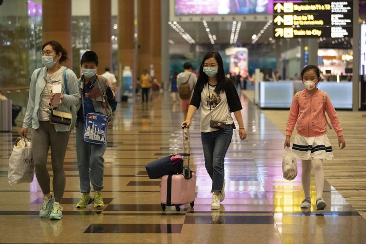 Wisatawan yang mengenakan masker terlihat di Bandara Changi di Singapura, 31 Januari 2020. Singapura menutup perbatasannya dengan wisatawan dari China.