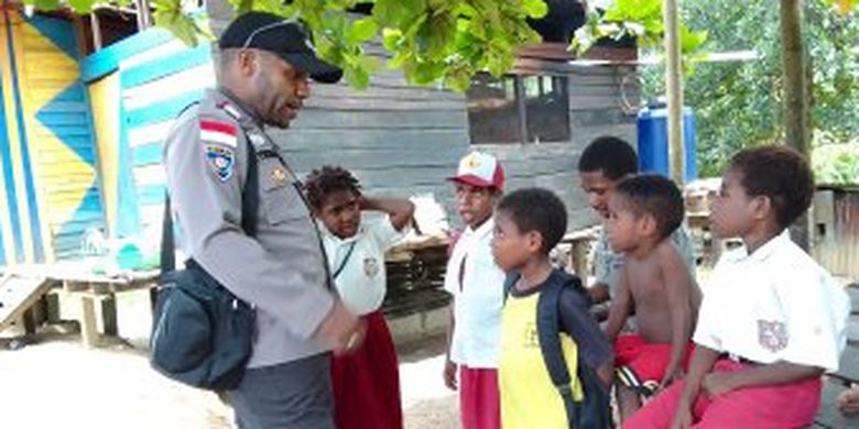 Bripka Batias Yikwa (pakai seragam polisi), saat berbincang-bincang dengan anak sekolah dari Dusun Baburia Gunung, Kampung Baburia, Distrik Arso Barat, Kabupaten Keerom, Papua belum lama ini.