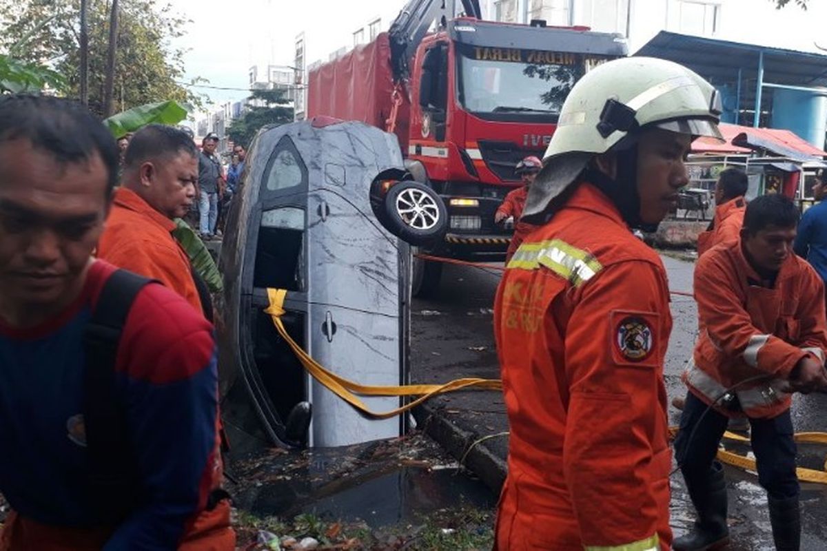 Sebuah mobil Daihatsu Sigra terperosok ke sungai di Jalan Rusun Indah Cengkareng, Jakarta Barat, Rabu (4/4/2018).