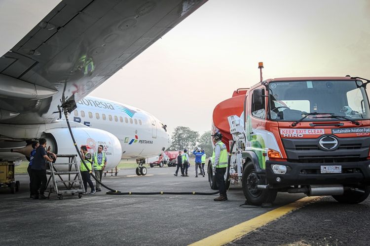 Beberapa pekerja mengisi bahan bakar turbin penerbangan (avtur) ke pesawat Garuda Indonesia.
