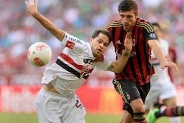 Bek AC Milan, Davide Pacifico (kiri) mencoba merebut bola dari striker Sao Paulo,  Silvinho pada laga perebutan tempat ketiga Audi Cup 2013 di Stadion Alliaz Arena, Kamis (1/8/2013). Hingga turun minum kedua tim bermain imbang 0-0. 