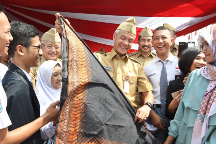 Gubernur Jawa Tengah Ganjar Pranowo menerima kado ulang tahun dari siswa SMA pada peringatan Hari Sumpah Pemuda di Alun-alun Kabupaten Pati, Minggu (28/10/2018)