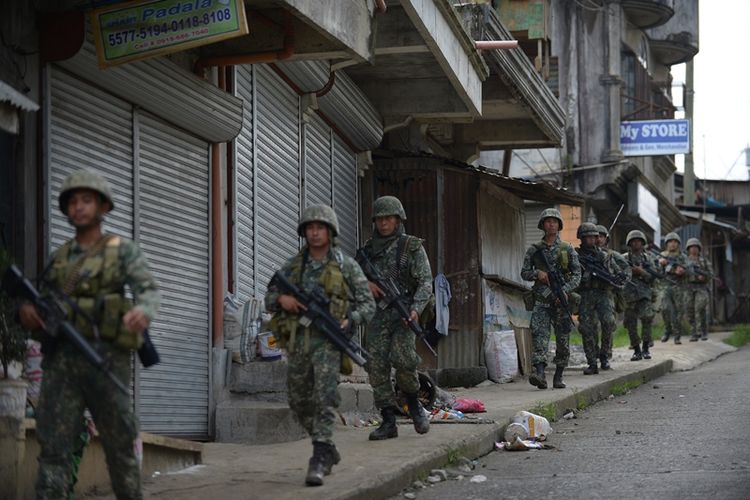 Pasukan marinir Filipina berpatroli di jalan-jalan yang sunyi akibat ditinggalkan penduduk di kota Marawi yang diserbu kelompok militan Maute.