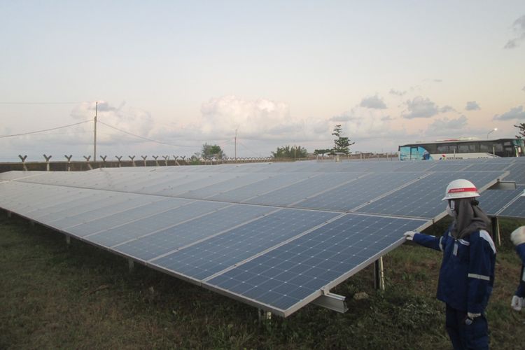 Pengunjung mengamati panel surya di pembangkit listrik tenaga surya (PLTS) Pertamina Refinery Unit (RU) IV Cilacap di area Rumah Sakit Pertamina Cilacap (RSCP) di Cilacap, Jawa Tengah, Selasa (28/6/2022).